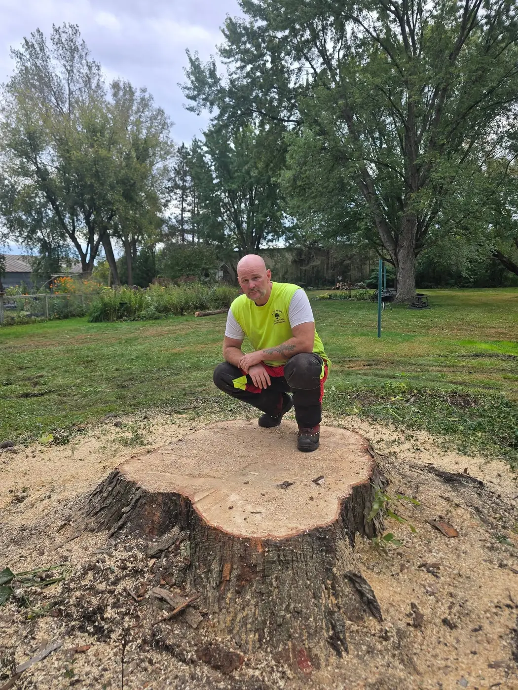 Mike from A Cut Above beside a large freshly cut stump in White Bear Lake MN
